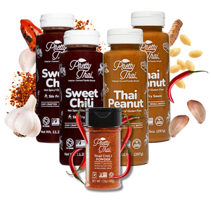 A pack of 5 Pretty Thai products. The products include two Sweet Chili Stir Fry and Barbecue Sauce bottles, two Peanut Dipping and Dressing Sauce bottles, and a Thai Chili power bottle. The Background is white and some vegetables can be seen.