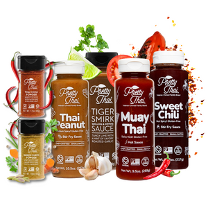 6 bottles of Pretty Thai products. sweet chili stir fry and barbecue sauce,   muay thai stir fry and dipping sauce,  tiger smirk grilling and dripping sauce,  peanut dipping and dressing sauce, Green Curry Powder, and Thai Chili Powder. The bottles are surrounded by vegetables and powder. 