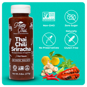 Front of Pretty Thai’s Thai Chili Sriracha Hot Sauce bottle on the blue background. In the bottom right corner, some vegetables and herbs can be seen. On top of these vegetables and herbs, 4 white icons are present. These icons read “Non-GMO, Zero Sugar, No Preservatives, and Naturally Gluten-Free”.