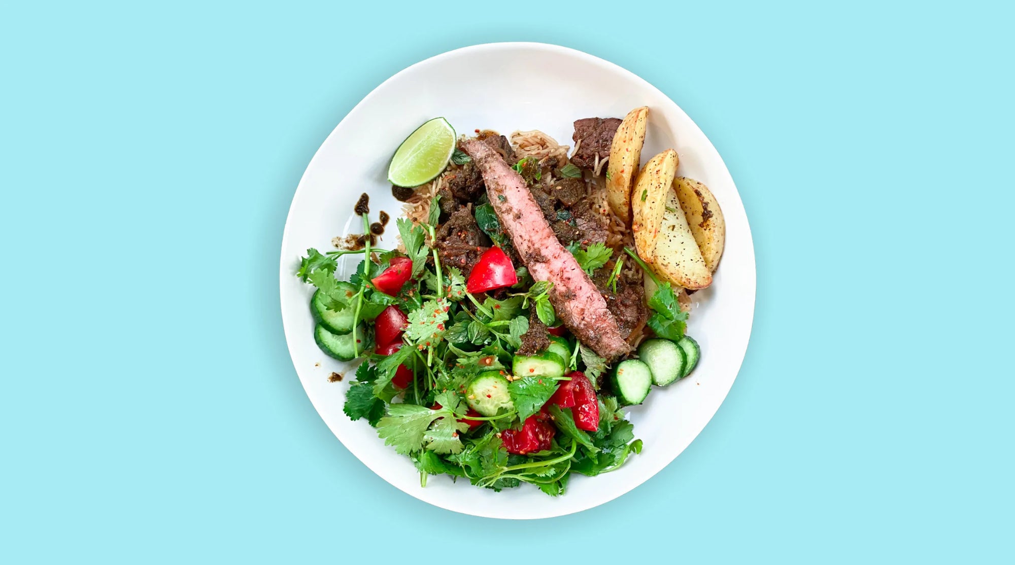 A white plate with Steak and vegetables on it on blue background can be seen.