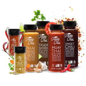 6 bottles of Pretty Thai products. sweet chili stir fry and barbecue sauce,   muay thai stir fry and dipping sauce,  tiger smirk grilling and dripping sauce,  peanut dipping and dressing sauce, Green Curry Powder, and Thai Chili Powder. The bottles are surrounded by vegetables and powder. 