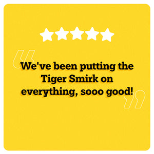 On a yellow background, 5 white stars can be seen in the center. Under the stars, “We've been putting the Tiger Smirk on everything, sooo good!” is written in black double quotes in bold black font. An illustration of two big white quotes can also be seen